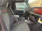 Spacious black Jeep Wrangler Rubicon interior with red accents & stitching. Ready for any RV rental adventure.