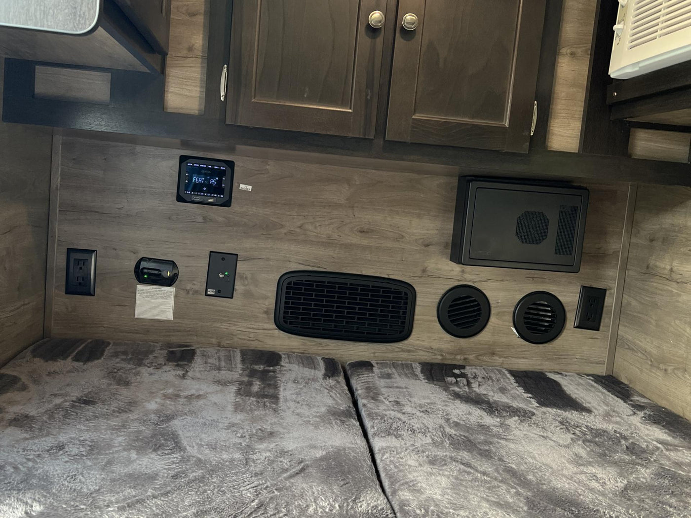  and vents over a cozy bed.|RV rental bedroom with split bed — photo 8