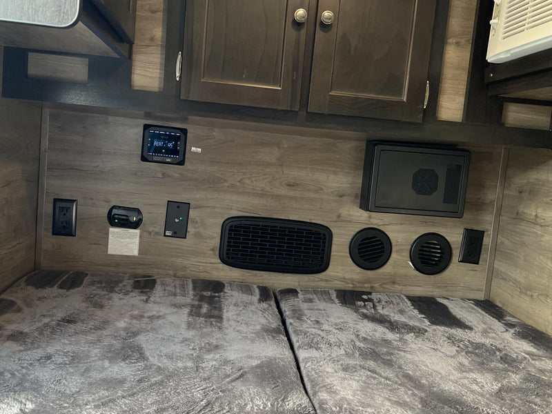  and vents over a cozy bed.|RV rental bedroom with split bed — photo 8