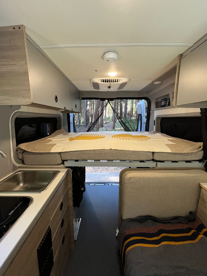  and ample storage for adaptable camping.|White RV rental van parked at night — photo 8