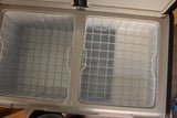 Clean, empty dual-zone portable refrigerator/freezer, ideal for your RV rental. Features white wire baskets for organized storage.