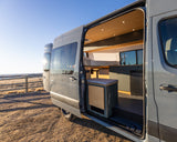 RV rental: Step into this modern camper van, showcasing its stylish interior with a bed, kitchen, and clever storage.