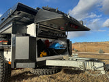 RV rental: Adventure-ready off-road camper trailer with open storage revealing gear. Perfect for outdoor exploration.