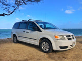 Minivan (RV rental) on a sunny Hawaii beach by the ocean, ready for island adventures.