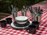 Durable enamel dishes, speckled mugs & cutlery for your RV rental outdoor dining on a red checkered table.