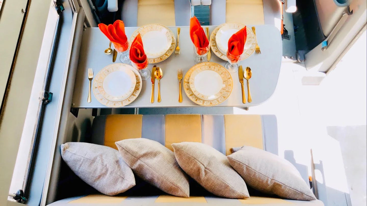 Elegant dining in an RV rental: golden cutlery, chic plates, red napkins, and comfy seat cushions create a luxurious travel space. — photo 12