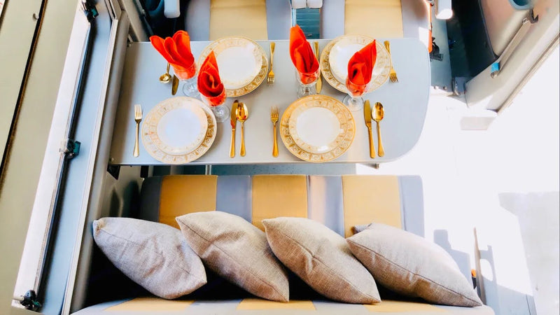 Elegant dining in an RV rental: golden cutlery, chic plates, red napkins, and comfy seat cushions create a luxurious travel space. — photo 12