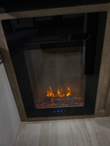 An electric fireplace with glowing faux flames and logs in an RV rental, showing control buttons below. Adds warmth & ambiance.