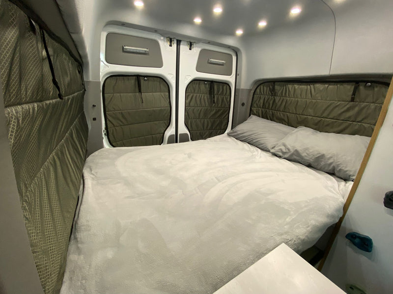 Cozy RV rental bedroom: large bed with light grey bedding — photo 1