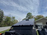 Top view of an RV rental with sleek solar panels on the roof, ready for off-grid excursions under a partly cloudy sky.