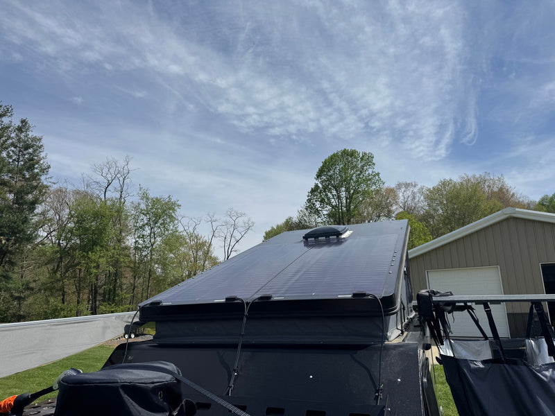 Top view of an RV rental with sleek solar panels on the roof, ready for off-grid excursions under a partly cloudy sky. — photo 13