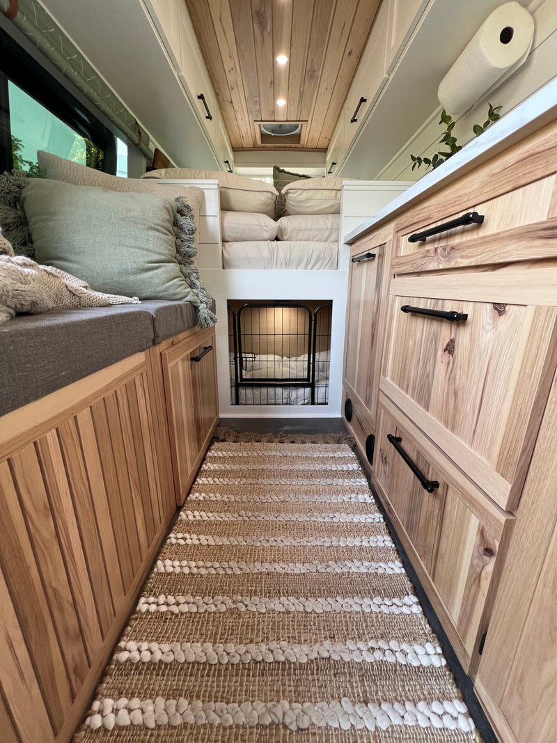  filled with organized utensils. A cozy bed and countertop are in the background.|RV rental kitchen sink cabinet: smart storage for cleaning supplies — photo 20