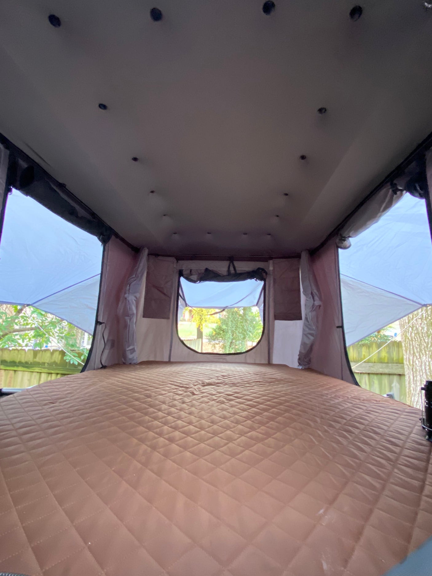 Spacious rooftop tent interior with a plush, quilted sleeping pad – ideal for your next RV rental getaway.