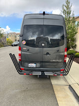 Gray Winnebago Sprinter van, an ideal RV rental, with rear carrier rack parked on a residential street.