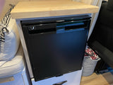 Built-in Dometic refrigerator and wooden countertop in a functional RV rental setup.