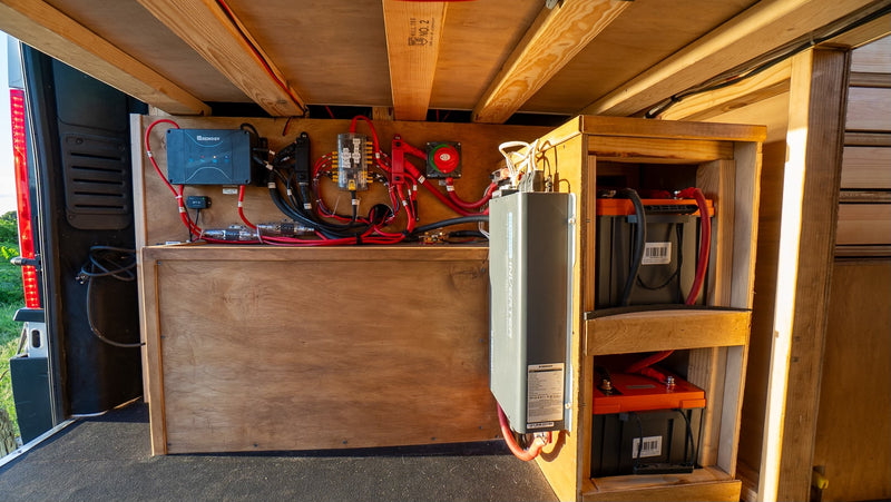 Inside an RV rental, a robust electrical system features a Renogy solar charge controller, inverter, and batteries for off-grid power. — photo 16