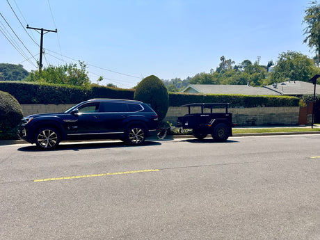 Explore outdoor adventures! Dark SUV tows a rugged XV-3 expedition trailer, perfect for RV rental trips on a sunny day.