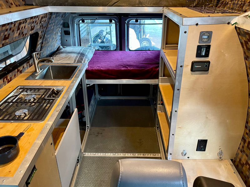  parked on a dirt road in a dense forest.|Inside a comfortable RV rental: a plush loft bed above the driver's area — photo 6