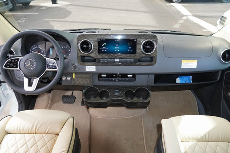 Modern Mercedes-Benz RV rental cockpit view: detailed dashboard, steering wheel, and large central infotainment system.