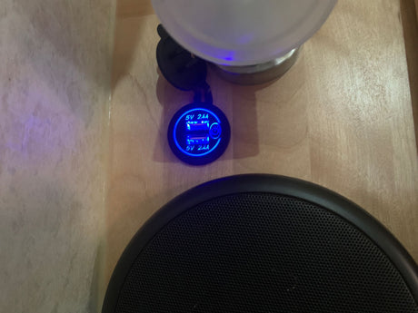 RV rental interior showing a dual USB charger (5V 2.4A) with blue light, next to a speaker, for convenient device charging.