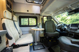 Interior of a modern rv rental camper van, featuring a versatile seating area with a table/laptop, and front cockpit view.