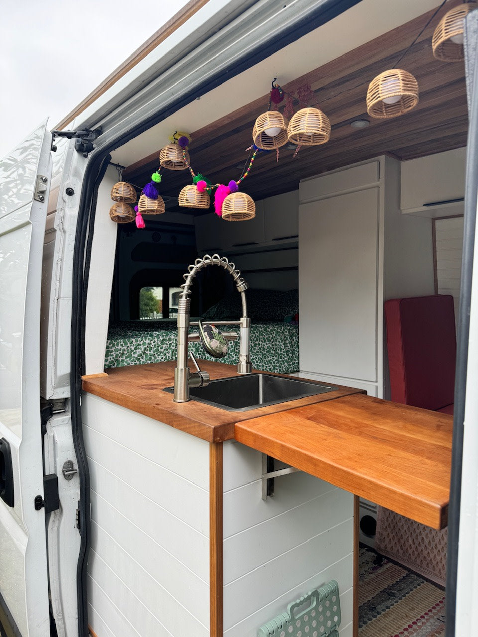  and cozy wooden ceiling.|Rear view of a white Ram ProMaster camper van with ladder & roof rack — photo 3