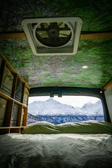 Wake up to stunning views! This rv rental offers a cozy bed, map ceiling, storage, & a vent with snowy mountain vistas.