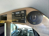 Inside an RV rental: a Jensen AWM975 stereo & Pyle speaker. Driver's cabin with Mercedes steering wheel reflected.