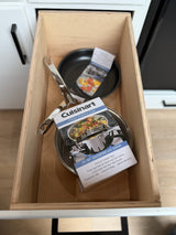 Cooking essentials for your rv rental: a Cuisinart 2 1/2 QT stainless steel saucepan and frying pan neatly stored in a wood drawer.