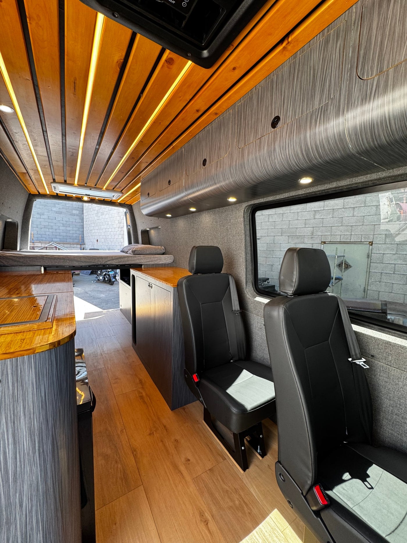 Spacious camper van interior, perfect for RV rental adventures. Enjoy the custom wooden ceiling, comfortable seating, and kitchenette. — photo 15