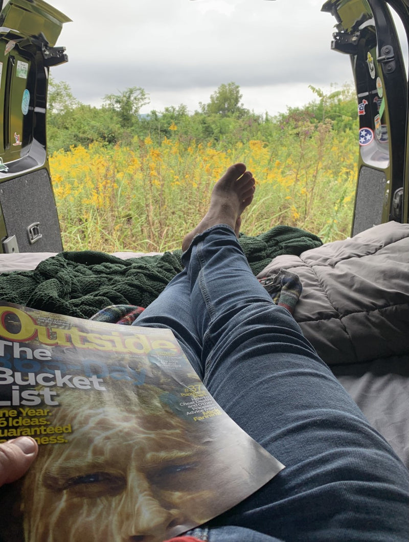 Enjoying an RV rental view of goldenrod fields while reading 'Outside' magazine's bucket list. — photo 4