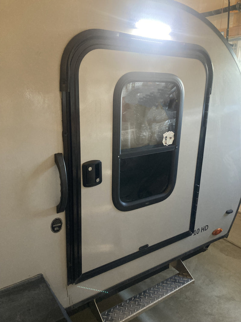 RV rental side view: A tan camper door with black trim, window, handle, and step. "210 HD" model visible. — photo 15