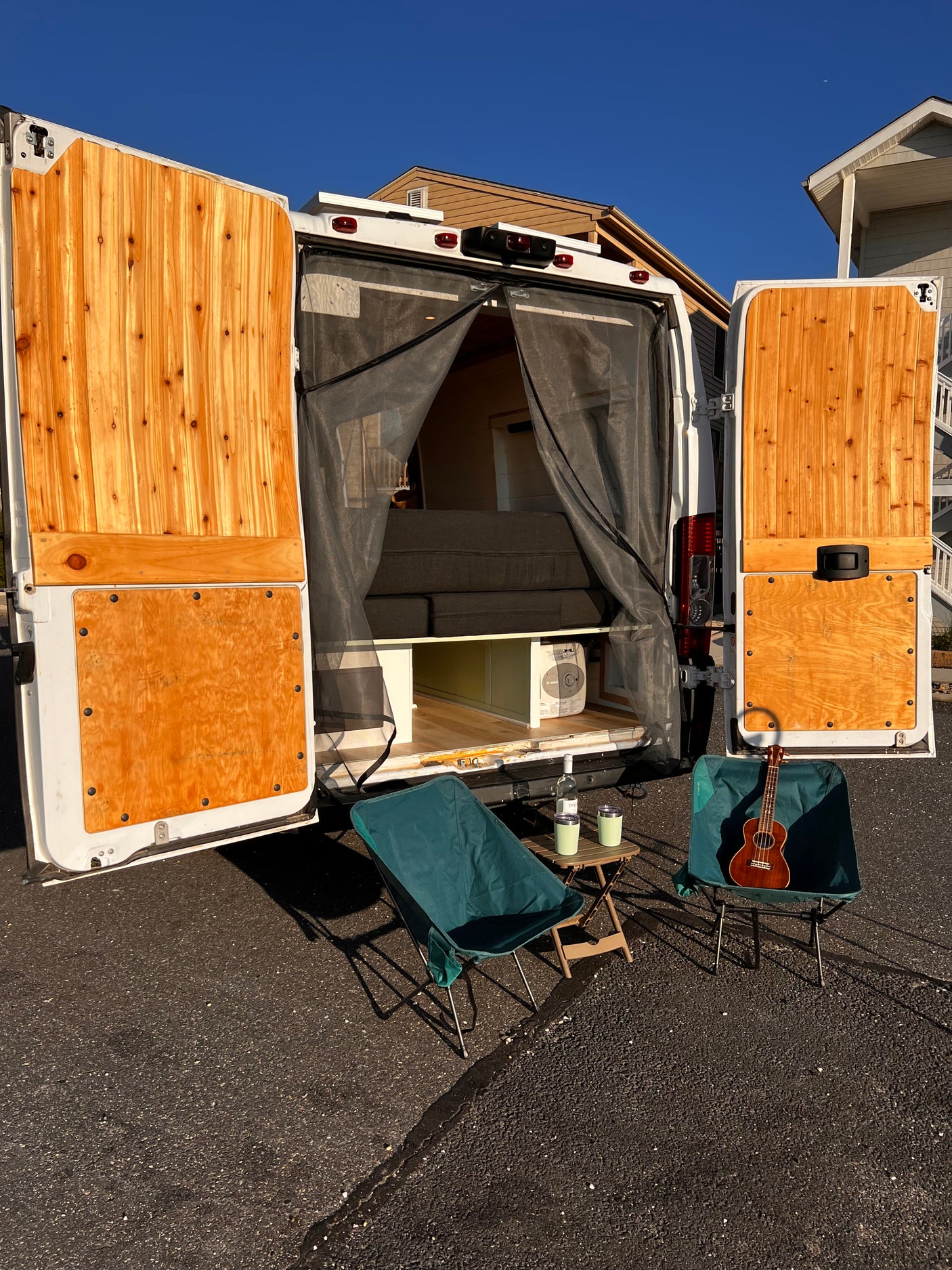 Cozy RV rental camper van with custom wood interior, ready for travel & outdoor relaxation. Perfect for van life adventures.
