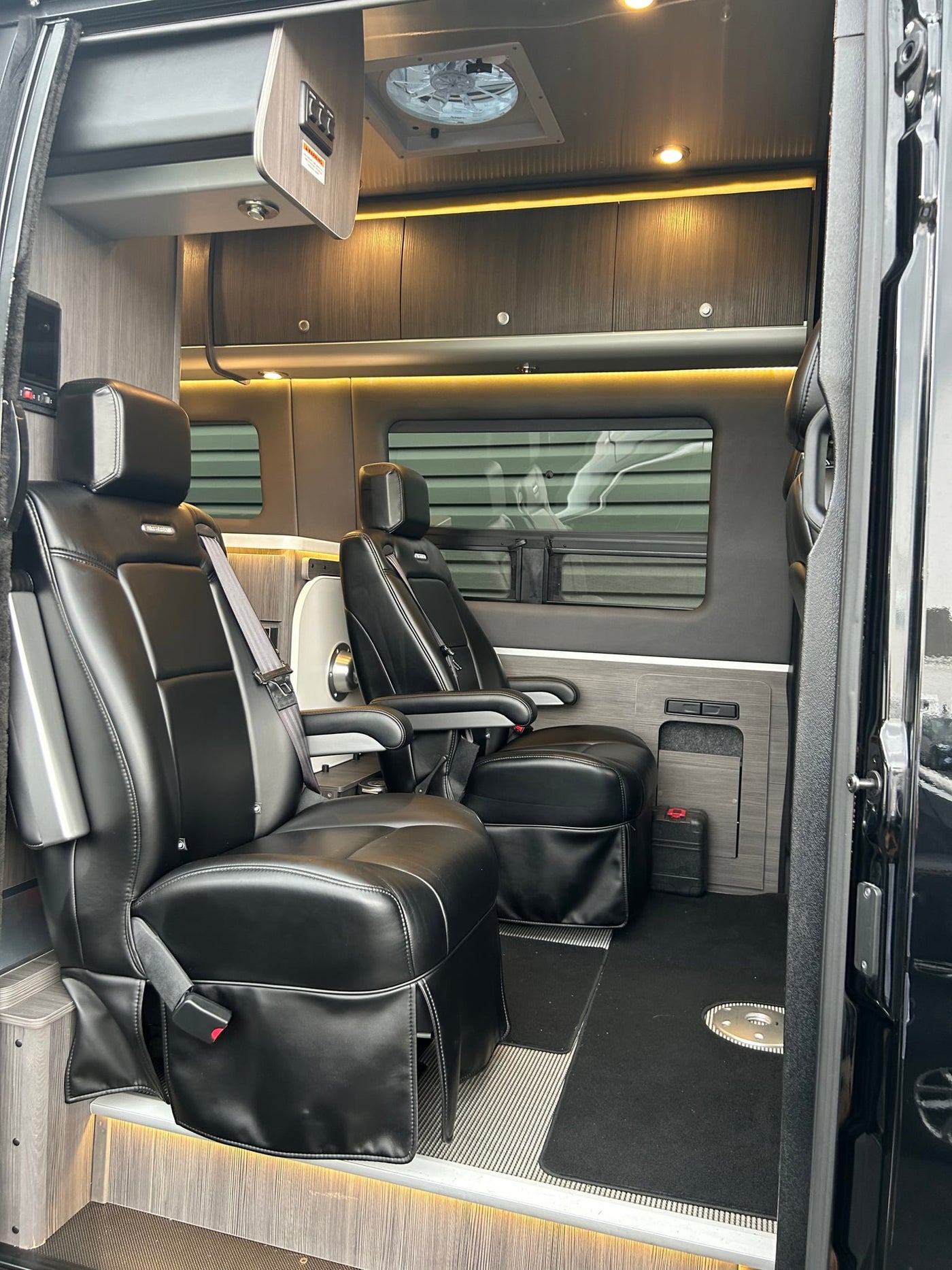  parked and charging its battery.|Black Airstream Sprinter RV rental with reflective windows and an awning — photo 4