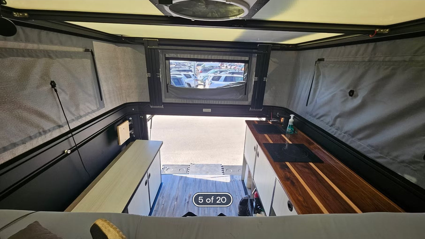  an ideal RV rental alternative for snowy forest camping adventures.|Grey Ford Raptor truck with pop-top camper parked in mountains for off-grid overlanding. Perfect RV rental adventure! — photo 5