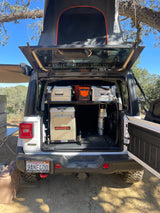 This white Jeep overlanding setup, with a rooftop tent and Engel fridge, is perfect for an adventure-ready RV rental.