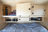 This rv rental offers a compact sleeping area with built-in storage: clothes, water bottle, mugs, shoes, lantern organized.
