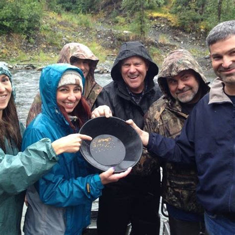 A happy group holding a pan of gold they found gold panning! Perfect for your RV rental outdoor adventure.