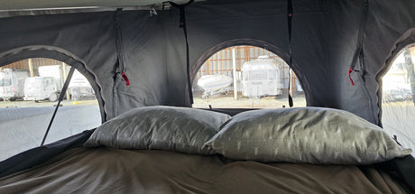 Cozy view from an RV rental, overlooking a storage lot with a truck, boat, and Airstream travel trailer.