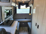 RV rental interior: cozy camper with kitchen, seating, and stunning lake view for your next adventure.