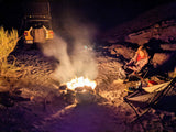 Camping by the fire with a Jeep and rooftop tent, ideal for an RV rental trip in the desert.