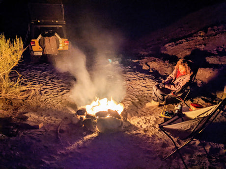 Camping by the fire with a Jeep and rooftop tent, ideal for an RV rental trip in the desert.