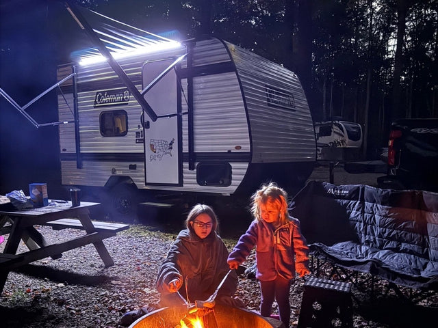 RV rental adventure: Kids enjoy s'mores by the campfire at night