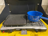 Coleman camp stove with a griddle and speckled blue pot, perfect for cooking in your RV rental.