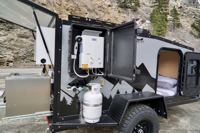 Compact RV rental camper with outdoor hot shower, pull-out kitchen, and cozy bed. Ideal for off-grid adventures.