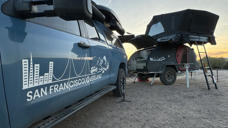 San Francisco Overland rv rental truck & teardrop trailer with rooftop tent in a desert camp setup.