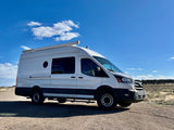 White custom camper van on a gravel road. Ideal RV rental for off-grid travel.|RV rental: Bright