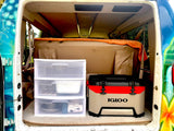 Rear view of RV rental van's organized interior: clear drawers with kitchenware & an Igloo cooler.