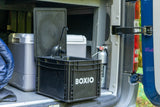 This rv rental features a practical Boxio portable sink, cooler, and fire extinguisher setup inside a camper van for convenience.
