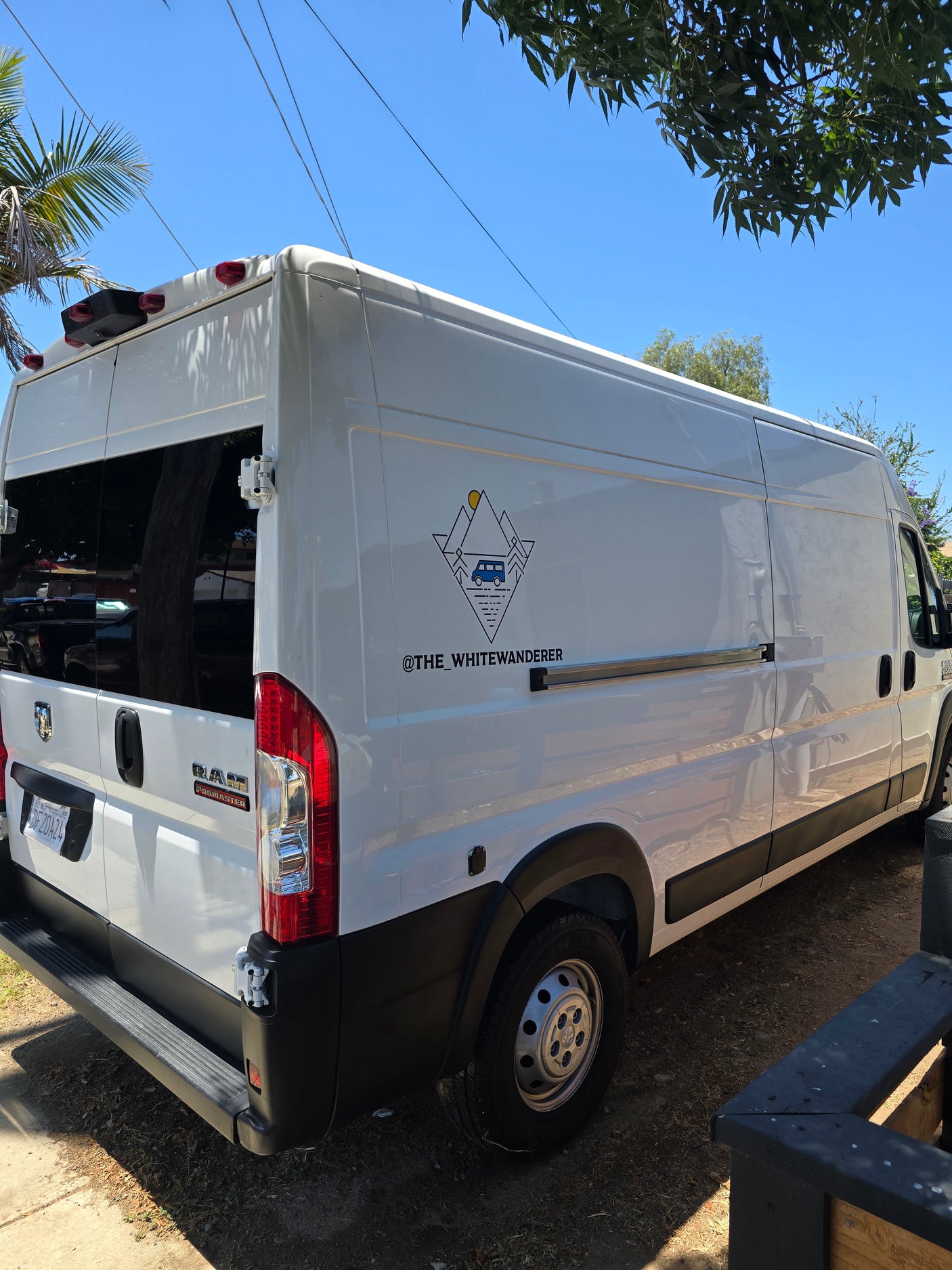Custom white Ram ProMaster van conversion, branded 'The White Wanderer,' ideal for an RV rental adventure.